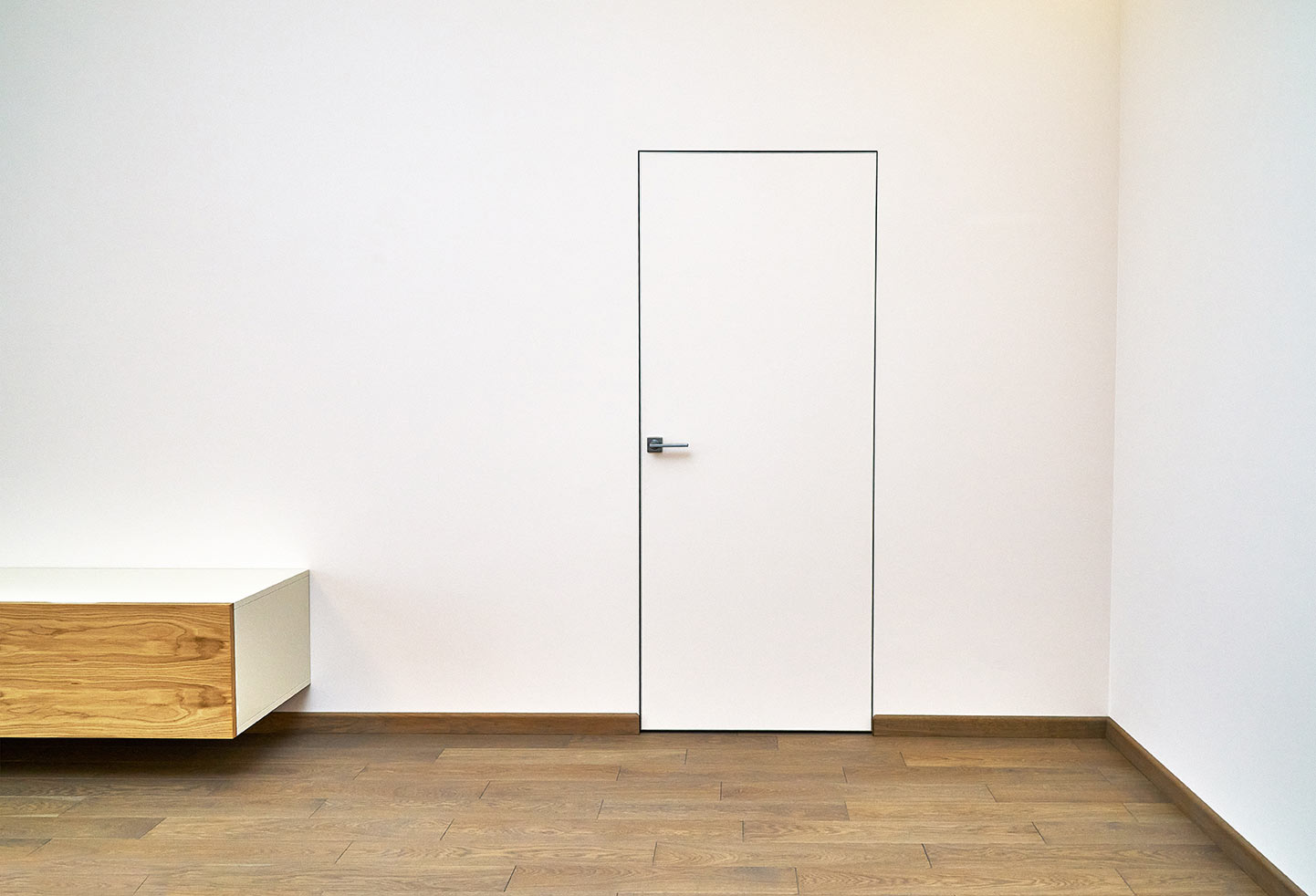 Schlichte rahmenlose Tür in Weiß neben Design-Sideboard